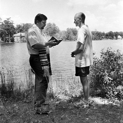 Two men at waterfront for Jewish ritual