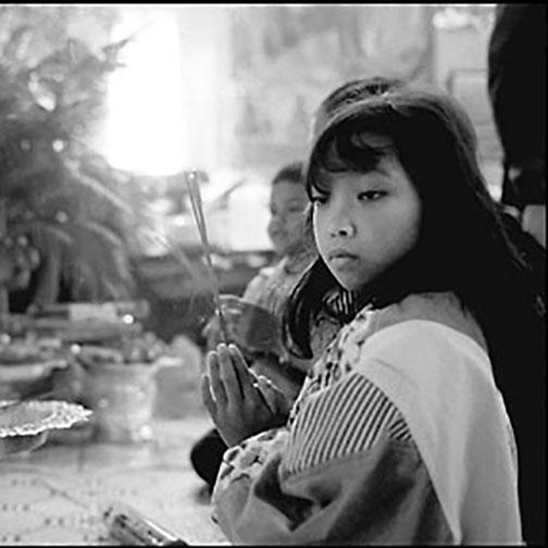 Child with incense at Buddhism temple